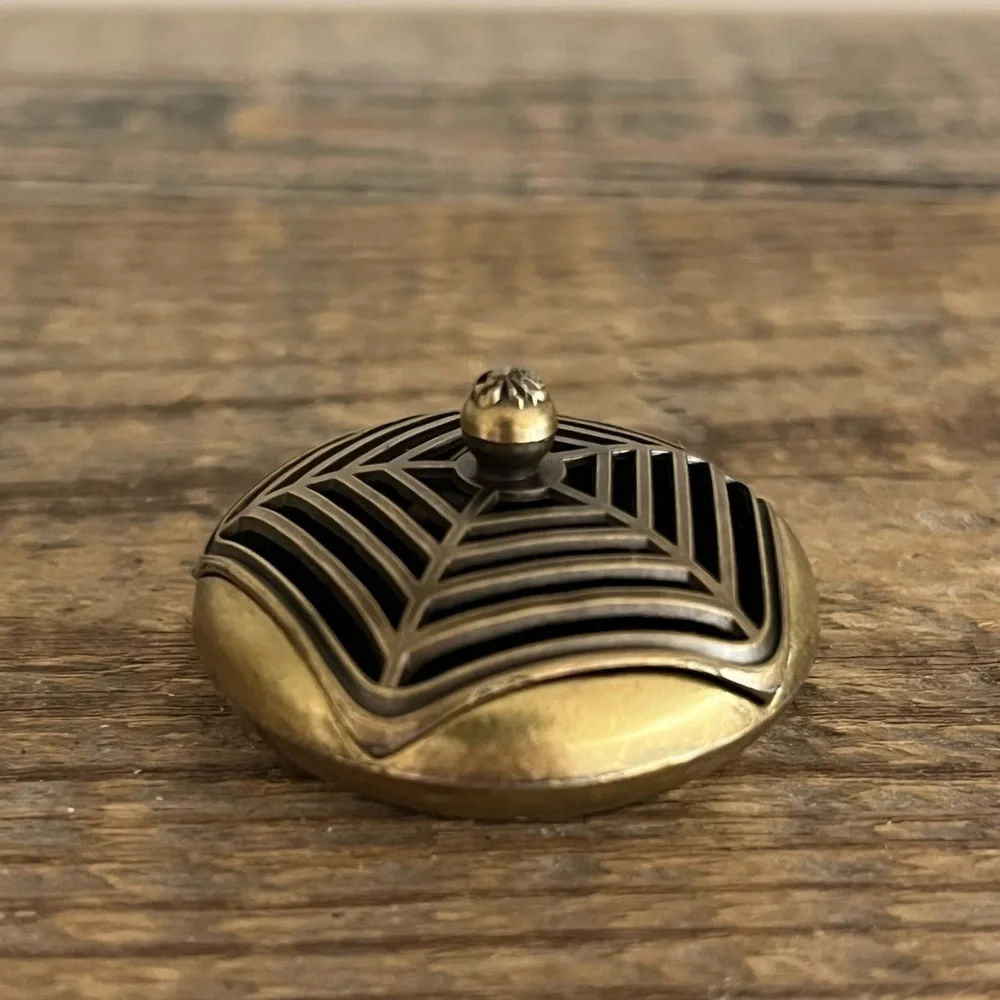 Brass spiderweb incense holder.